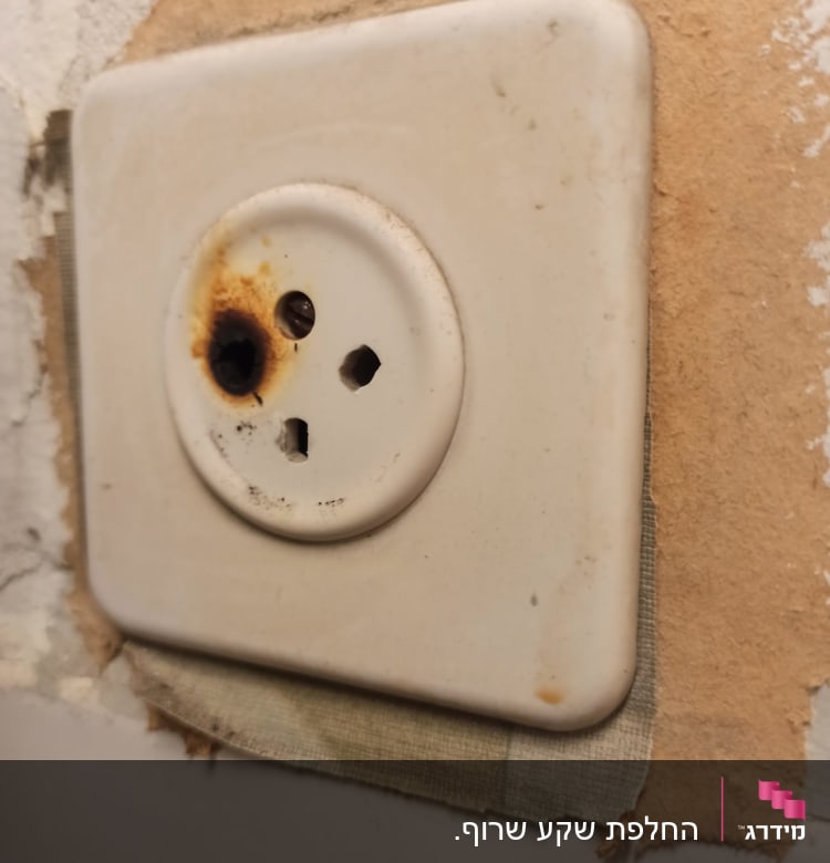 שקע חשמלי עם סימני שריפה על הקיר